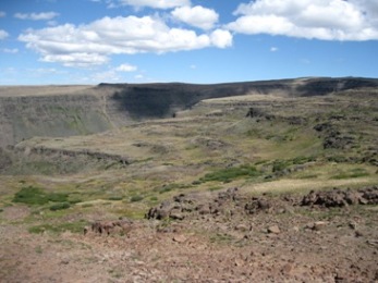 The upper plateau is brushy and rocky with expansive views